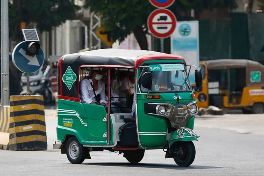 A Grab tuk-tuk drives along the streets of Phnom Penh